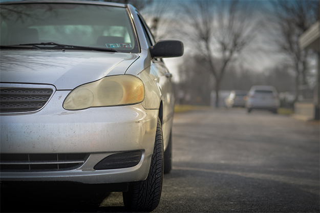 Car with cloudy headlights in need of replacement.